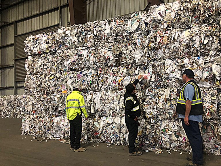 MDRR Employees standing in front of paper bales at the MRF